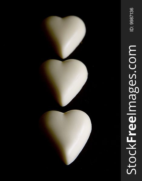 White chocolate love heart isolated against a black background