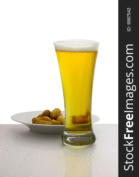 Glass of beer and bowl of peanuts isolated on white