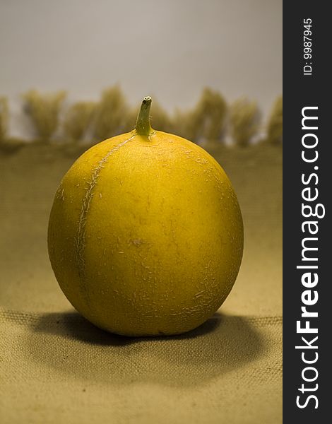 View of a yellow melon on top of a fabric. View of a yellow melon on top of a fabric.
