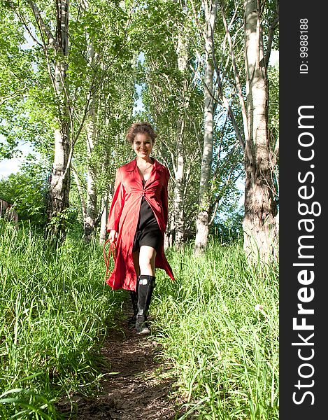 Young girl in red cloack, walking in the park
