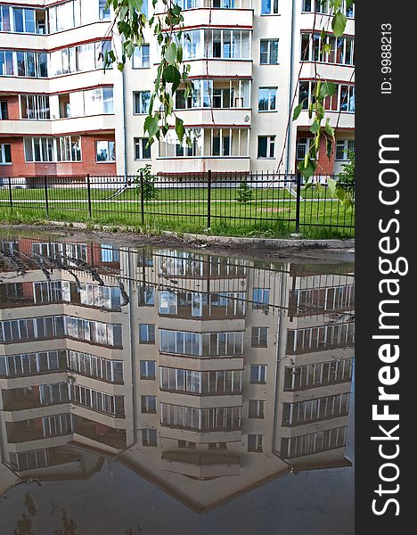 Reflection of a modern building in a puddle. Reflection of a modern building in a puddle