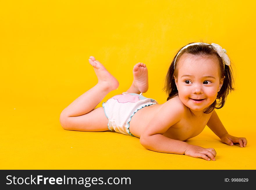 Cute little girl on the floor over yellow