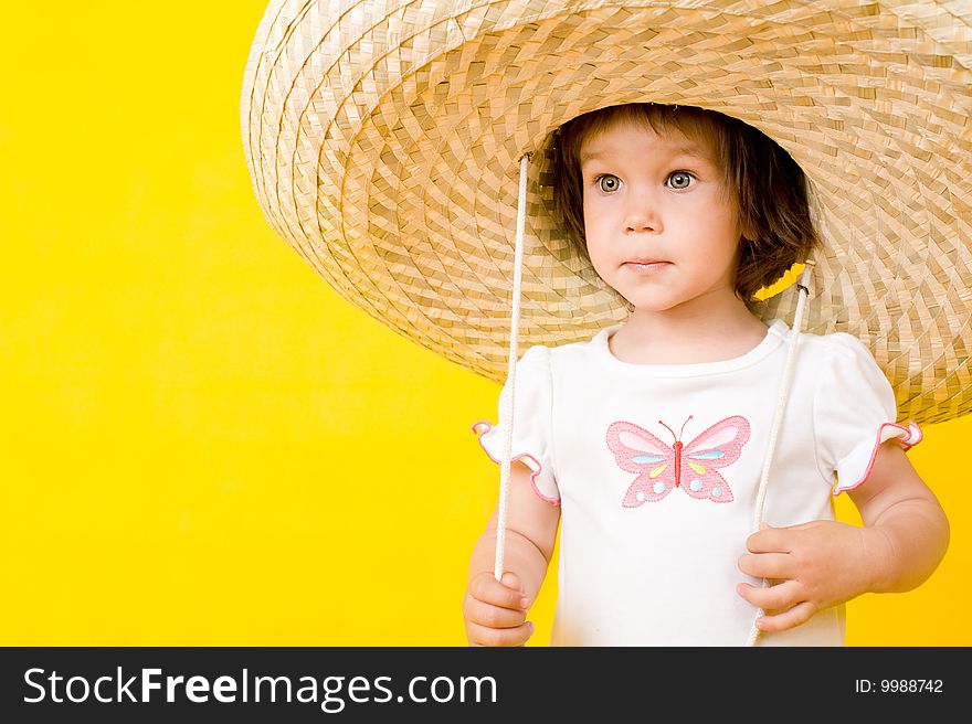Little baby with big hat, Isolated on yellow