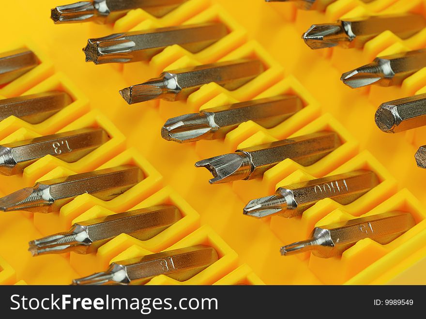 various screwdriver arranged in rows with yellow background