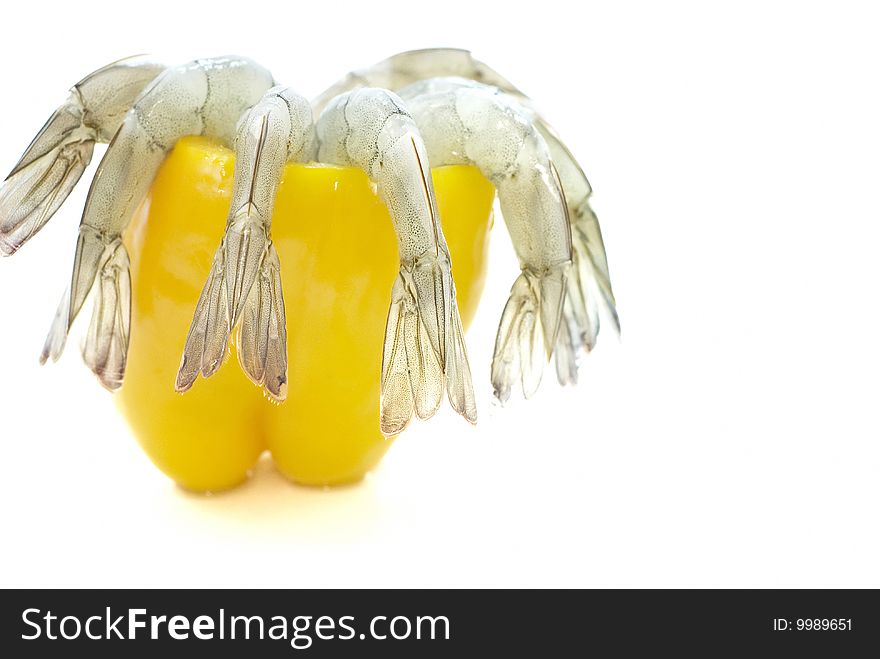 shell off vannamei prawns in emptied yellow pepper isolated on white background taken from side