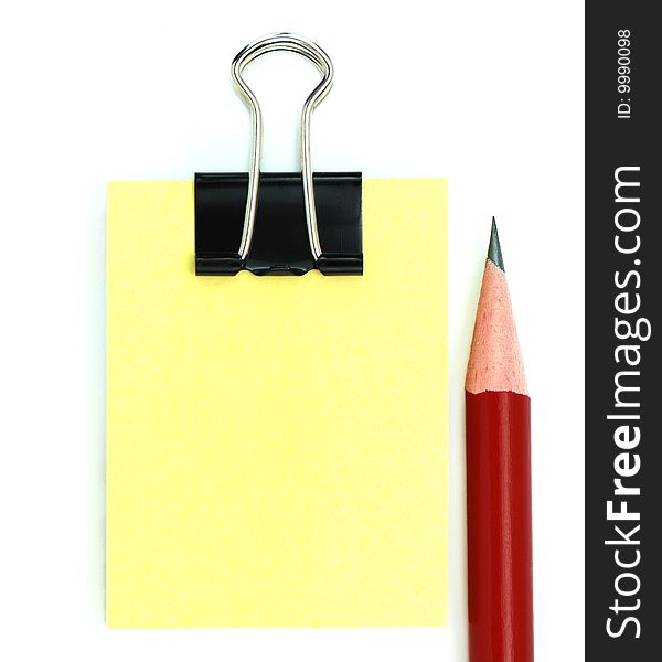 Red pencil, black clipper, and yellow notepad isolated on white background
