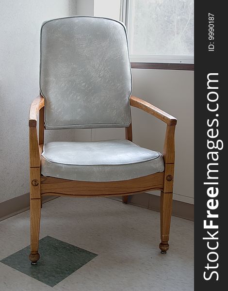 A lone chair sitting the corner of a hospital room. A lone chair sitting the corner of a hospital room