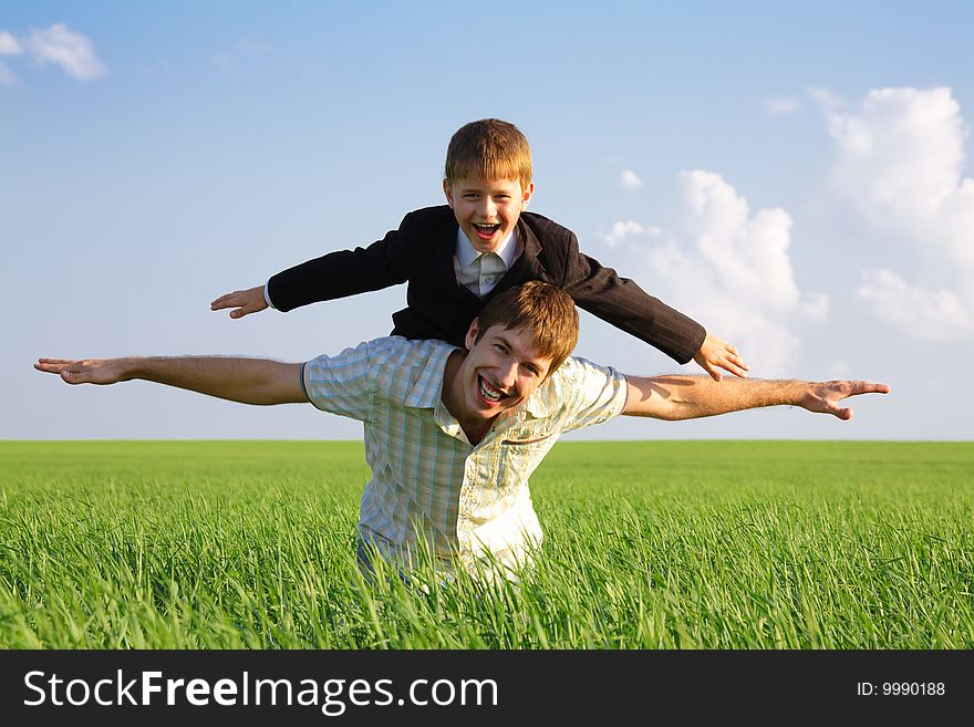 Photo of happy man with his son on back stretching their hands. Photo of happy man with his son on back stretching their hands