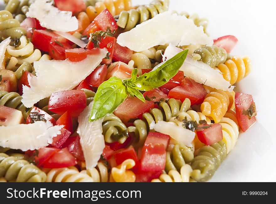 Pasta primavera garnished with basil leaves