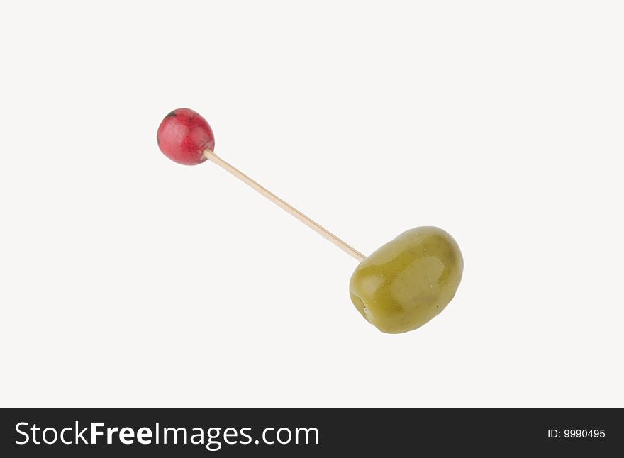 Toothpick and green olive isolated in white background