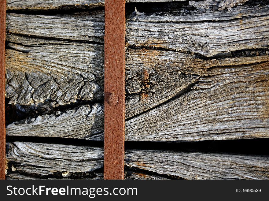 Closeup view of a old piece of wood wrapped with a rusty metal. Closeup view of a old piece of wood wrapped with a rusty metal.