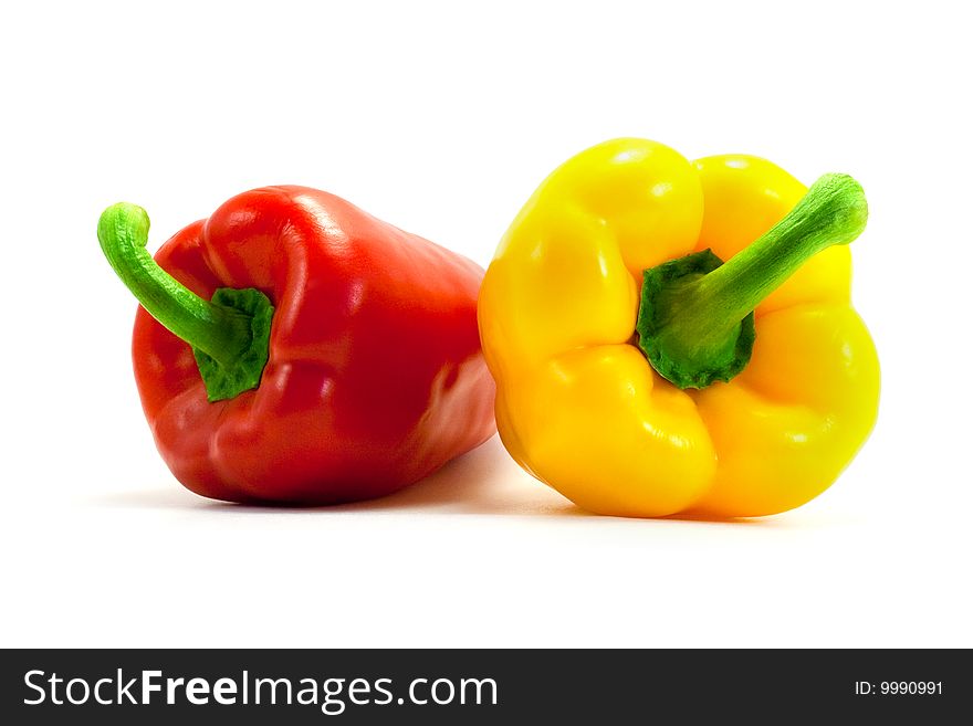 Yellow and red shiny ripe appetizing peppers on a white background. Yellow and red shiny ripe appetizing peppers on a white background