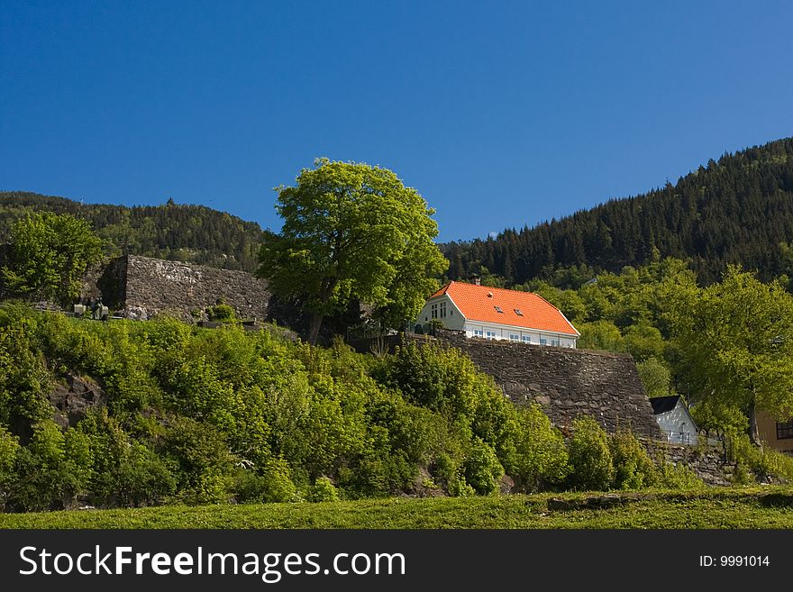 Small house next to ancient wall. Bergen, Norway.