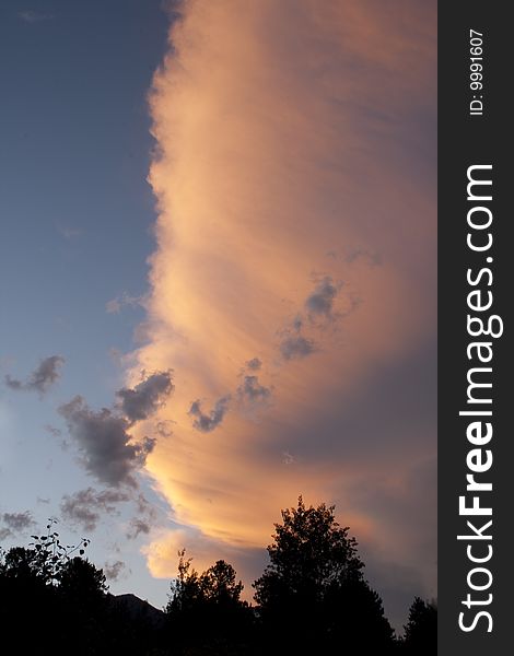 The tail end of a weather system, reflecting the last light of day in vivid colors.