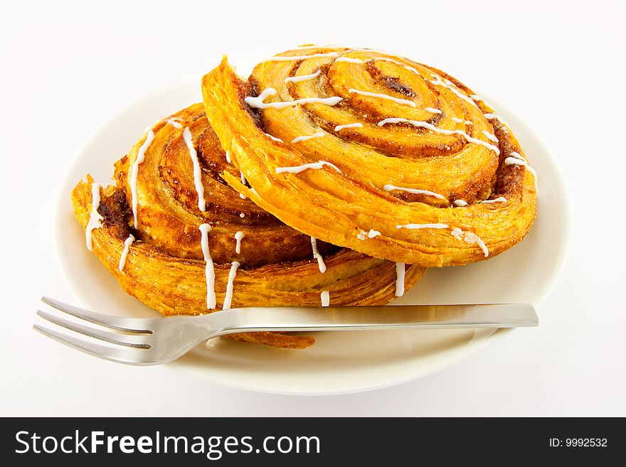 Two cinnamon buns and fork with clipping path on a white background