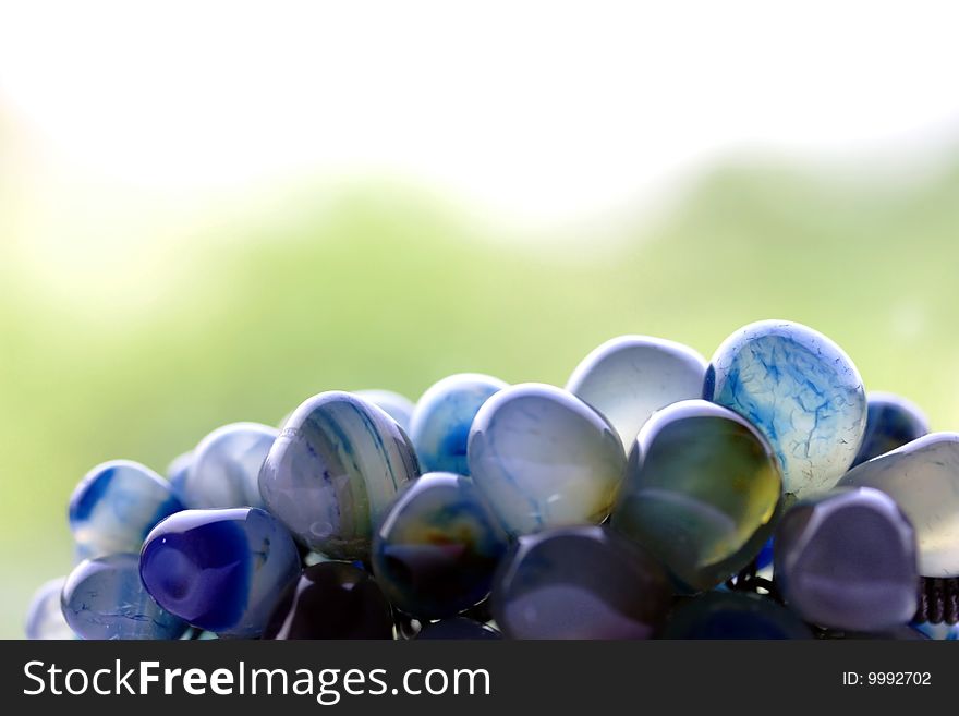 a close up picture of smooth polished blue veined stones with green background.