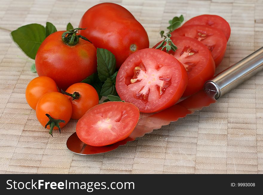 Tomato slices with tomatos and herbs on cutting board