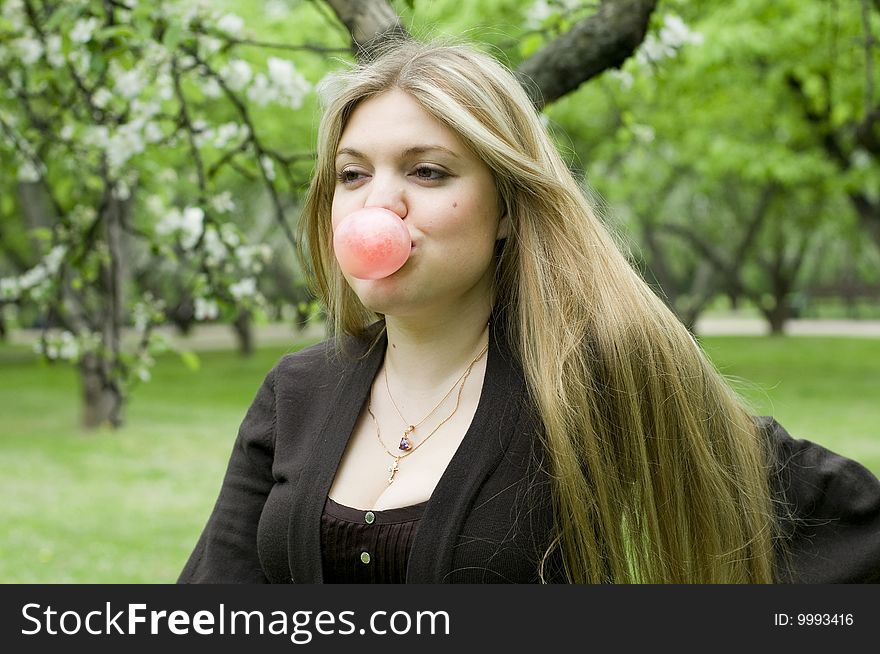 Playful blond girl blowing bubble with bubble gum