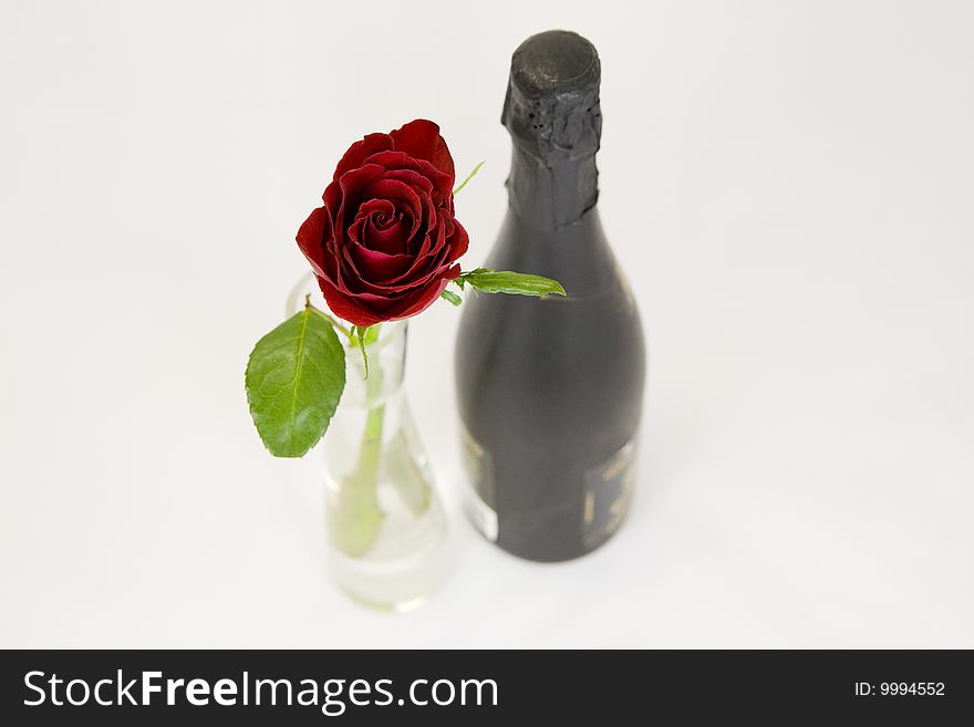 A beautiful red rose and a bottle of champagne. A beautiful red rose and a bottle of champagne