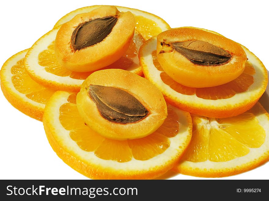 Apricots on orange slices on white background