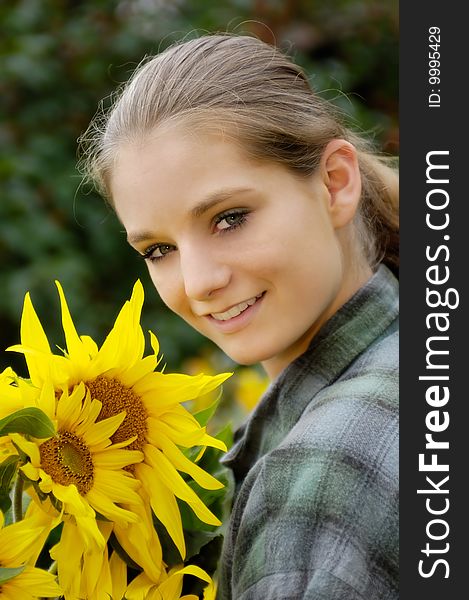 Pretty young gardener woman with sunflowers. Pretty young gardener woman with sunflowers