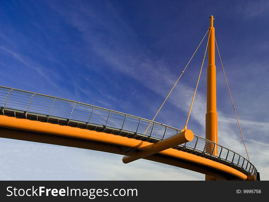 A orange rope bridge in blue sky