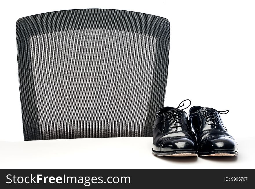 A pair of black business shoes on a white desk