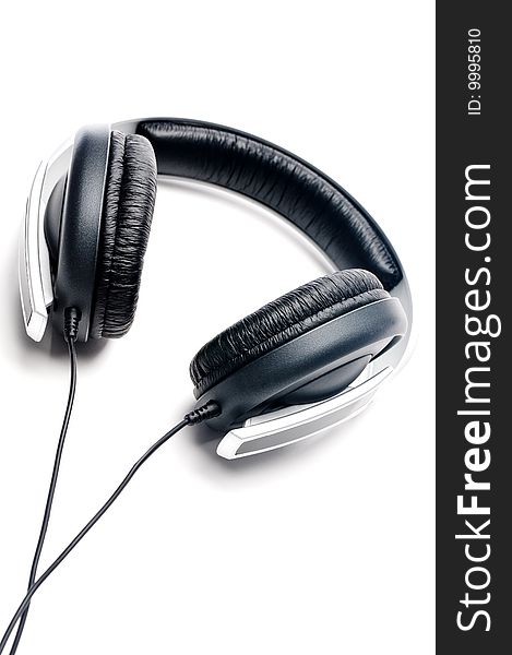 Tilted vertical image of silver colored headphones with black leather padding