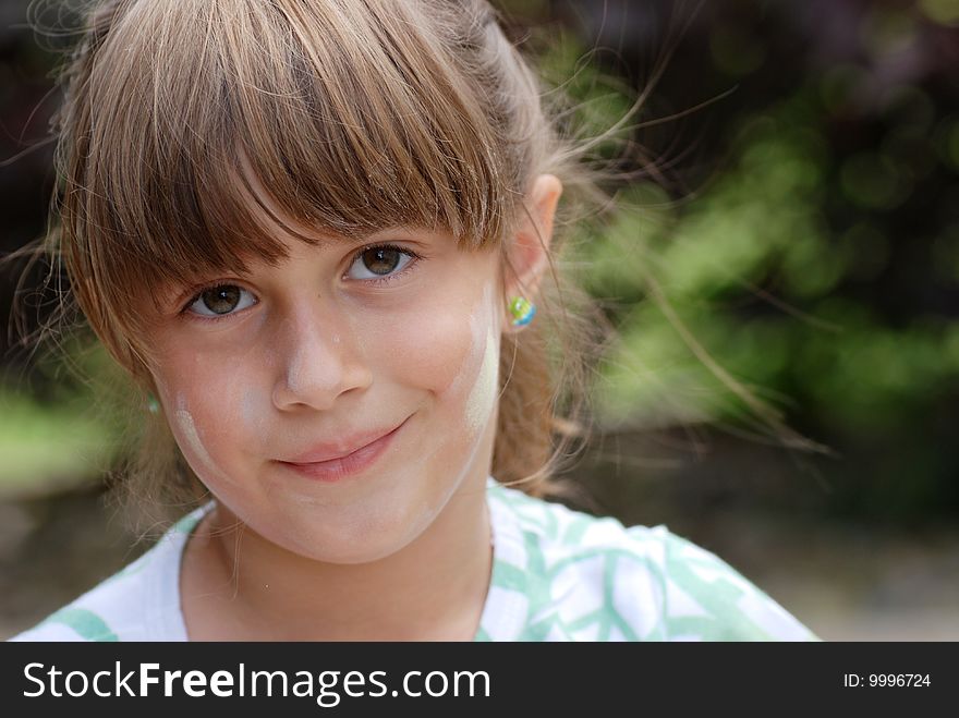 A portrait of a cute young girl with chalk on her face. A portrait of a cute young girl with chalk on her face