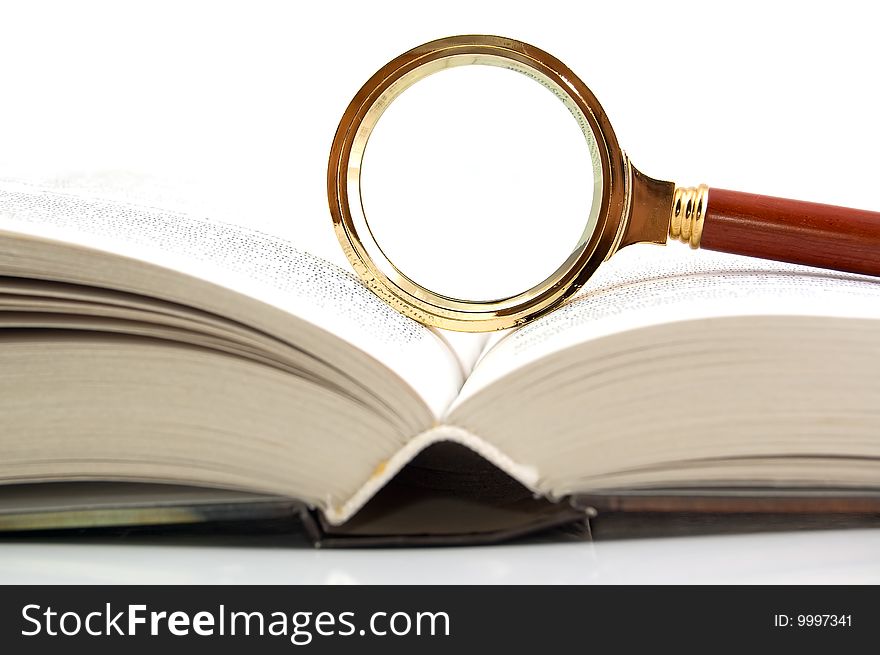 Magnifier and the book. A white background. Close-up.