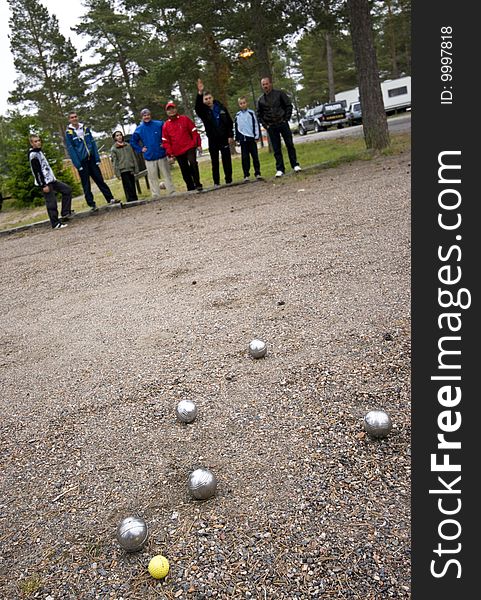 Group of men and boys playing boulle together. Focus on the balls. Group of men and boys playing boulle together. Focus on the balls.