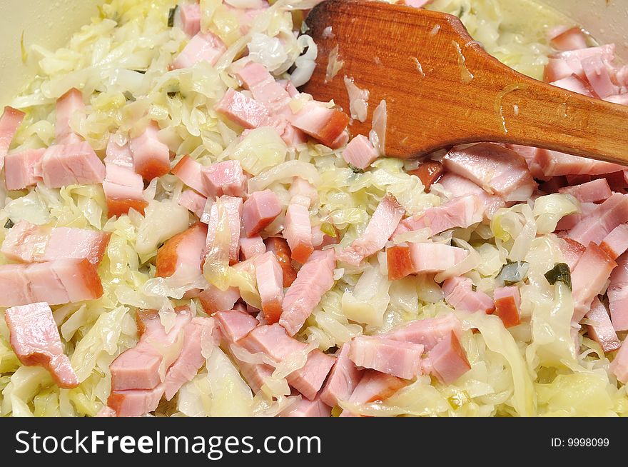 Cooking cabbage with ham in a pan