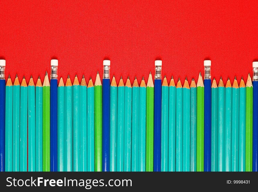 A lot of pencils on red backgrounds, focus on middle group of pencils