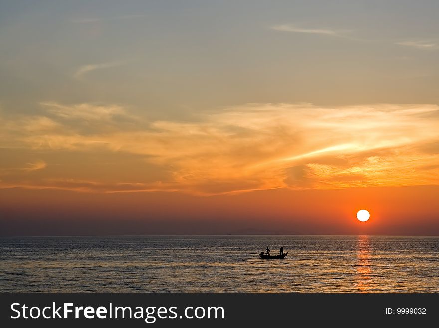 Sunset and two fishman on the boat in Thailand