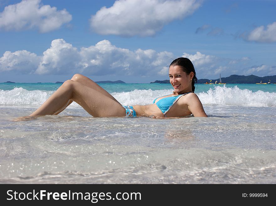 A girl lying down on her back in shallow water. A girl lying down on her back in shallow water.
