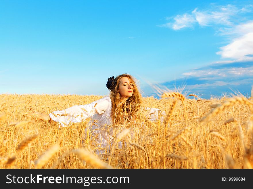 Woman relaxing in wheat field at sunset. Woman relaxing in wheat field at sunset