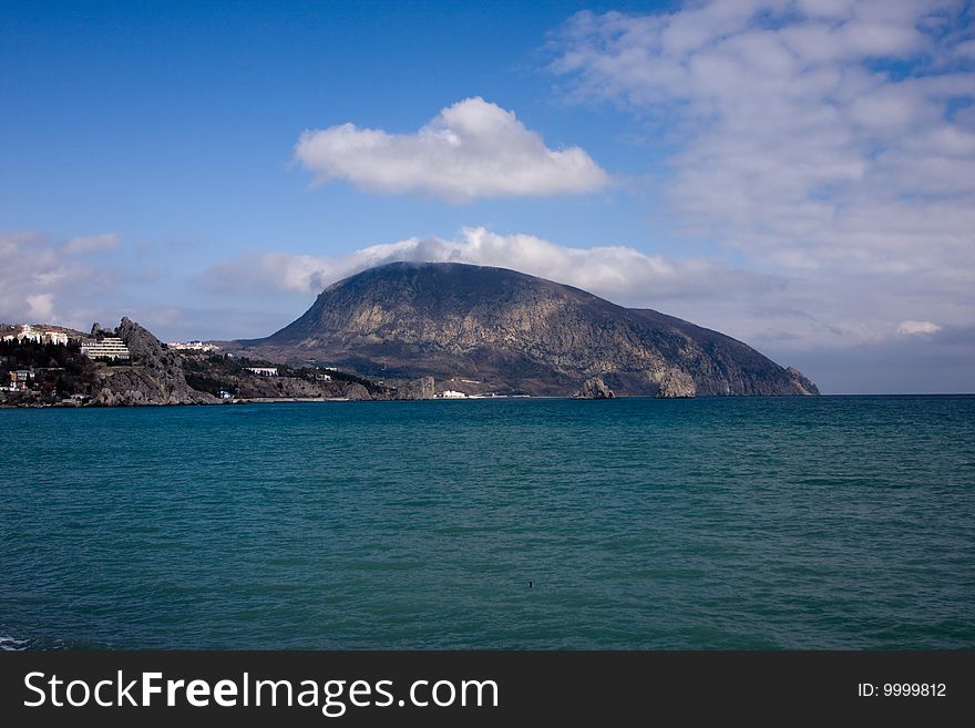 View of mountain near the sea and blue sky with clouds. View of mountain near the sea and blue sky with clouds