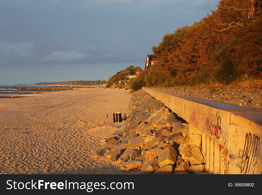 A long sandy beach with rocks.