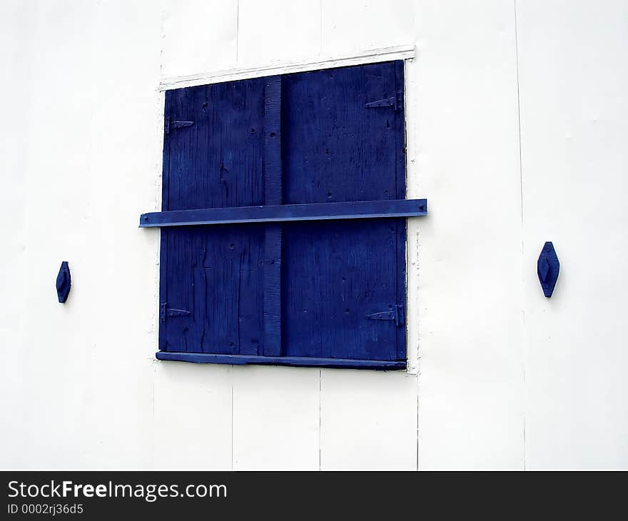 Blue Window on white building that is closed up! Abstract, exposed