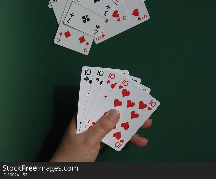 A hand with cards with green background. A hand with cards with green background.