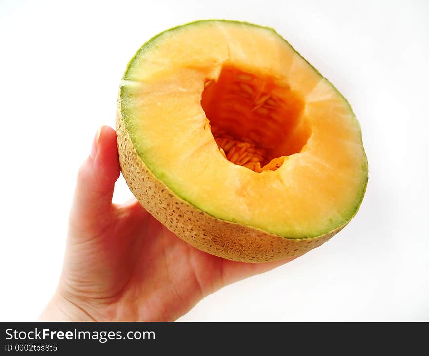 Hand holding a juicy cantaloupe.