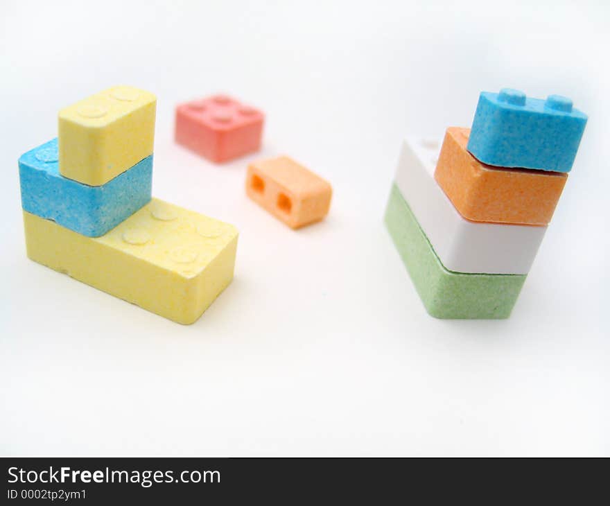 Colored candy blocks scattered on white background. Focus on front blocks. Colored candy blocks scattered on white background. Focus on front blocks.