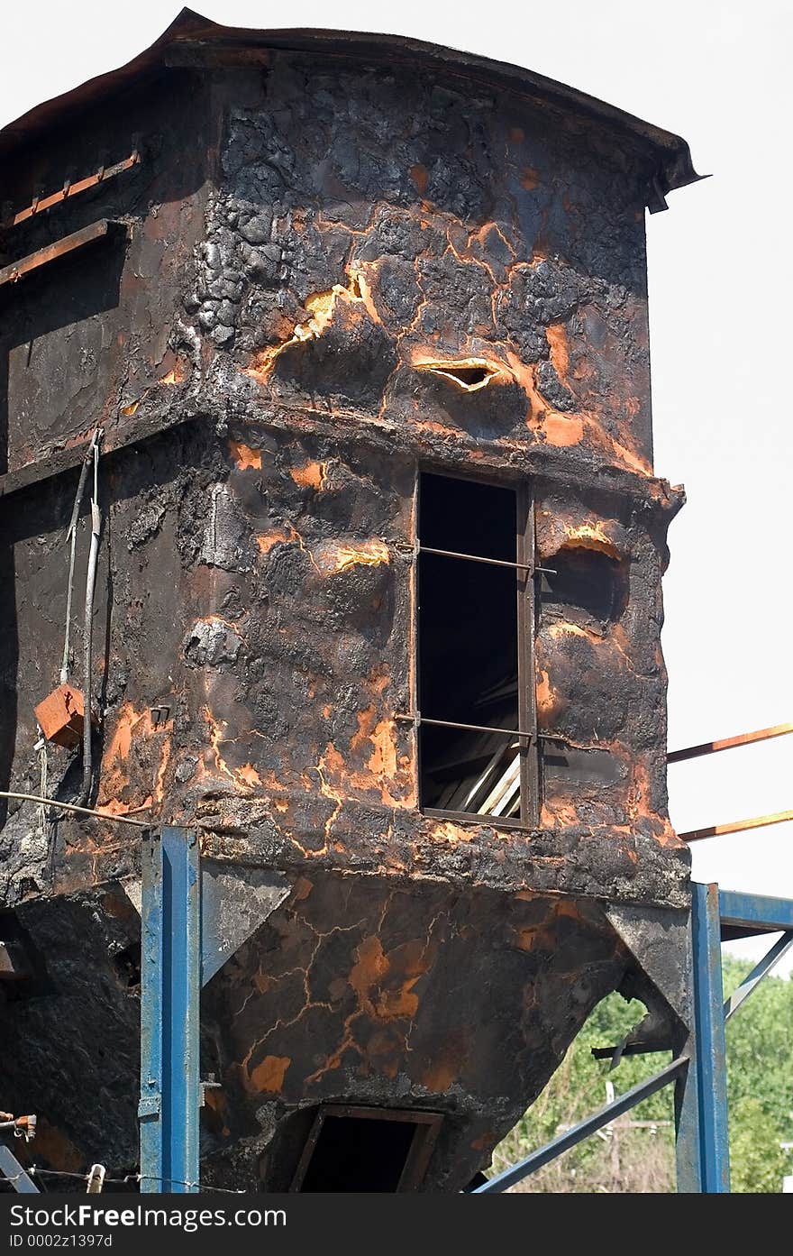 A hopper that was involved in a magnesium fire, insulation is charred and deformed, entire surface of structure is black. A hopper that was involved in a magnesium fire, insulation is charred and deformed, entire surface of structure is black