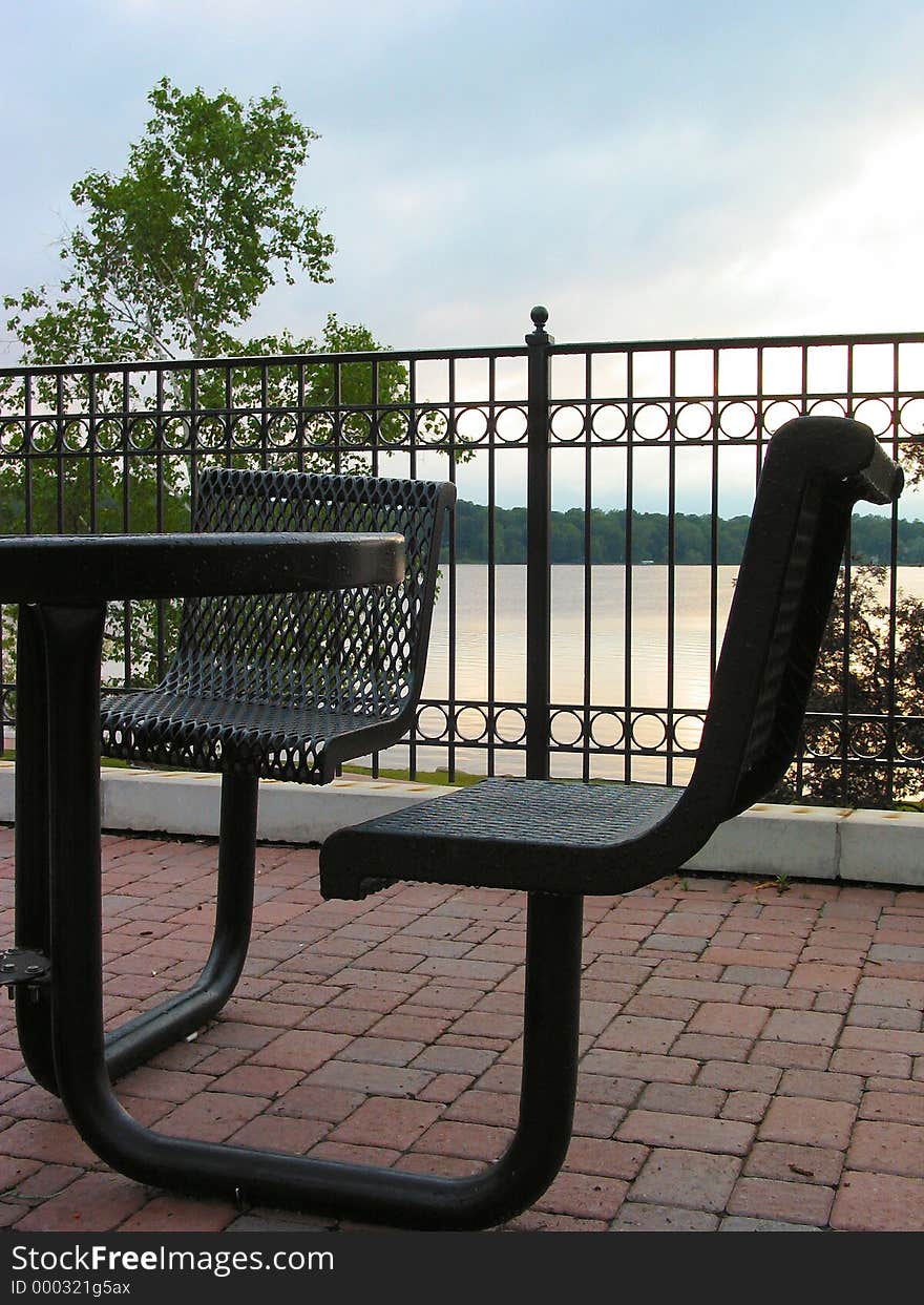 Table located in a park located near a lake. Table located in a park located near a lake.