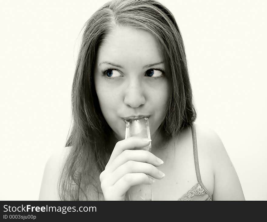 Woman in gray/yellow pale tones sucking on freezie treat. Woman in gray/yellow pale tones sucking on freezie treat.