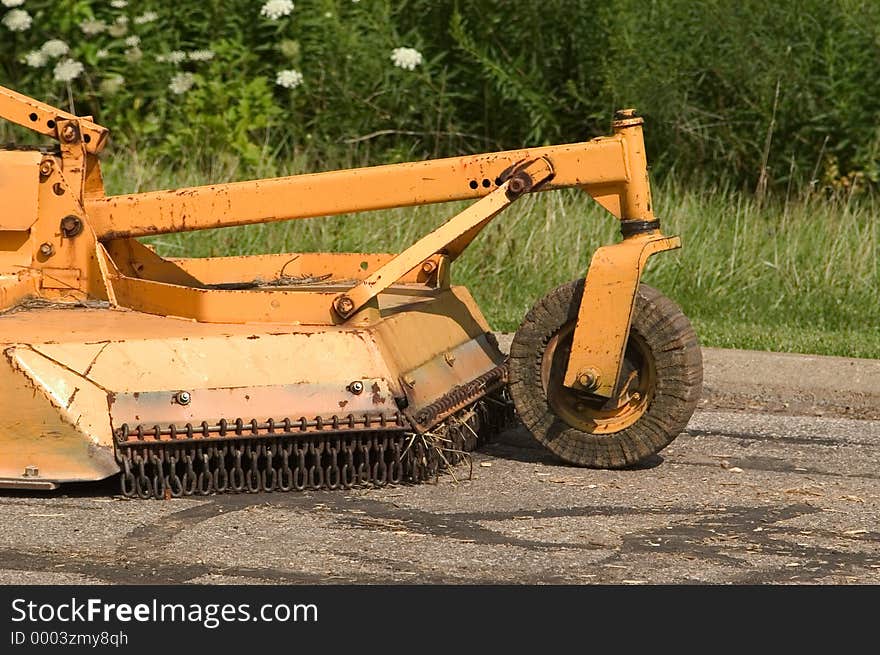 A large mowing attachment to a tractor commonly refered to as a brush hog in farming communities around the States.