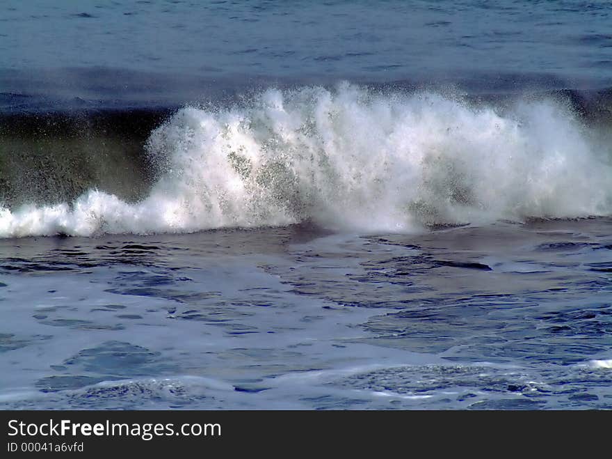 Wave crashing on shore, no horizon or location identification. Wave crashing on shore, no horizon or location identification