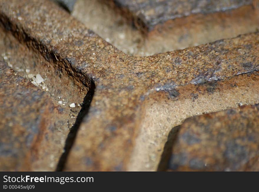 A close-up shot of thepatterns in a manhole cover. A close-up shot of thepatterns in a manhole cover