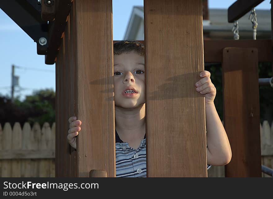 Photo of Child Looking From Behind Wooden Posts. Photo of Child Looking From Behind Wooden Posts.