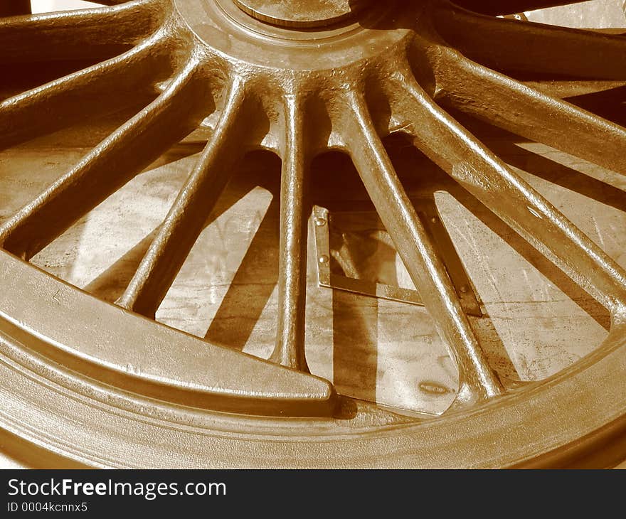 Historic locomotive wheel in sepia tone.